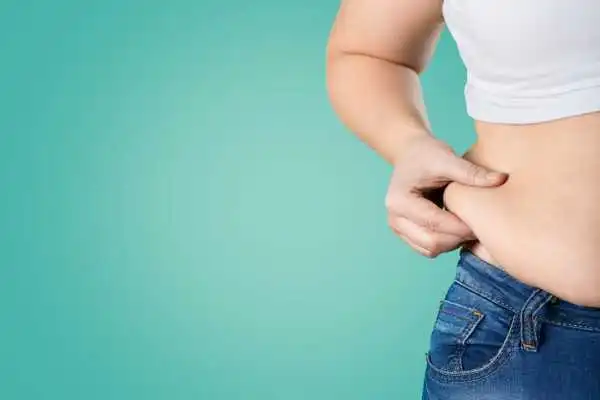 Image of woman pinching her love handles to show weight gain Tipton