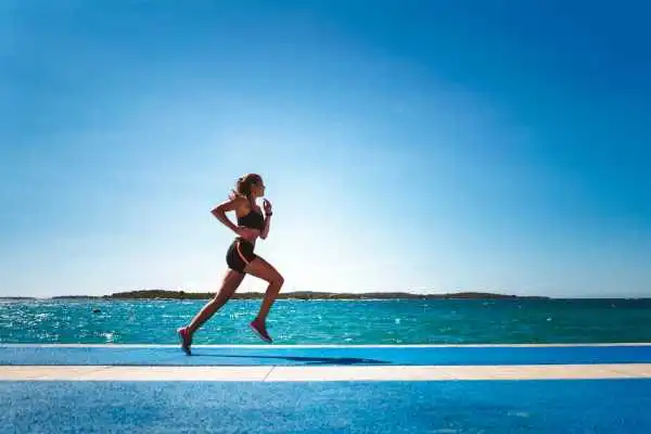 Woman running showing strong leg muscle Tipton